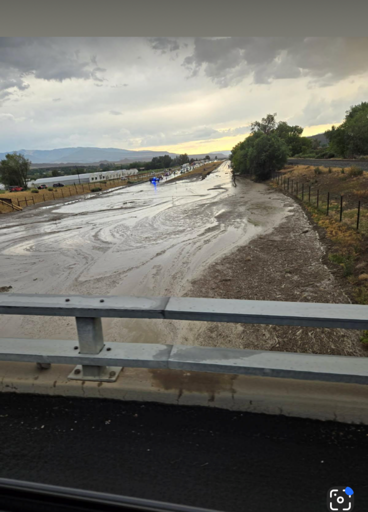 Water and mud sitting on I-70 with vehicles waiting.