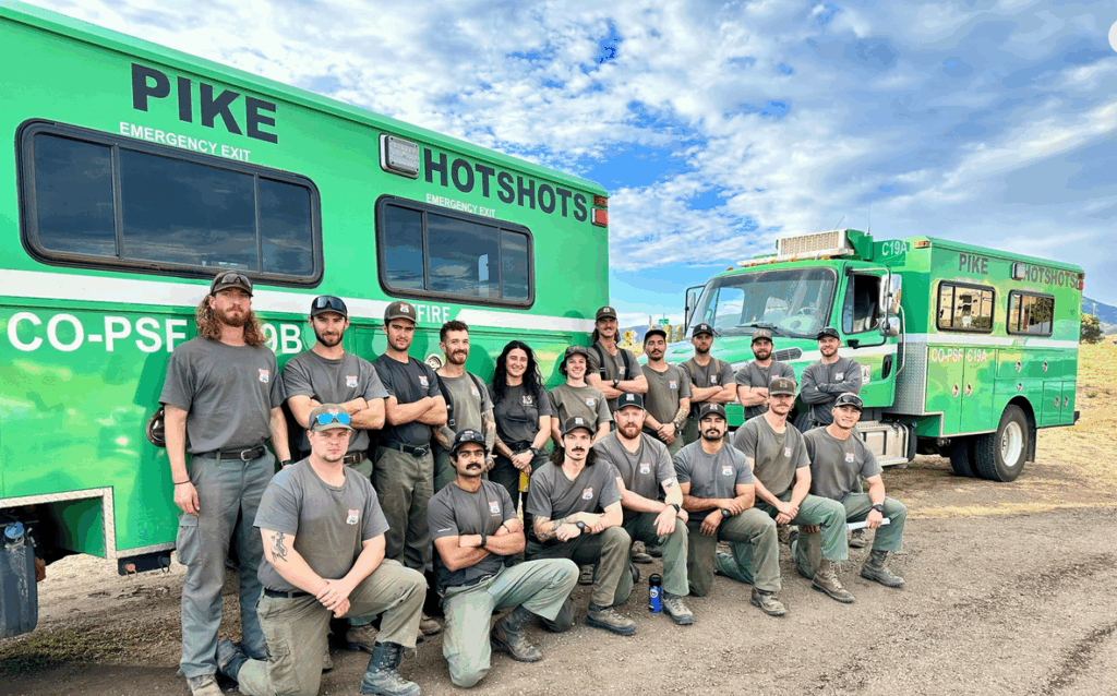 Photo of Pike Hotshots fire team with transport trucks