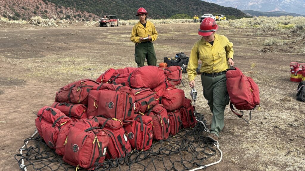 Firefighters earlier this week helping to load supplies onto a helicopter to take to hotshots in a remote area of the Derby Fire