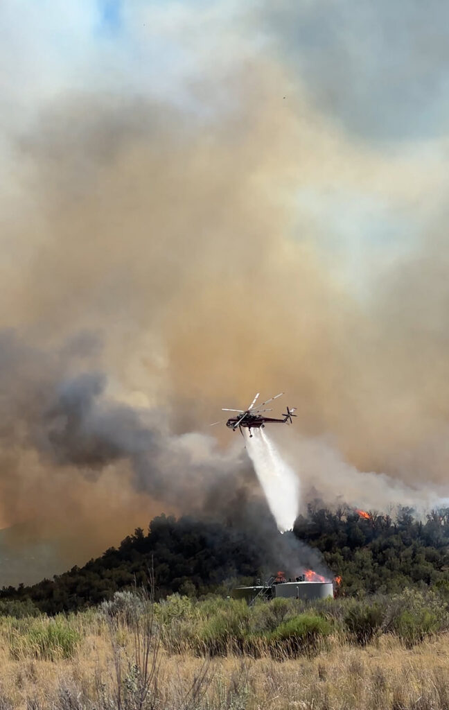 Firefighting helicopter drops water on the Dry Creek Fire. 