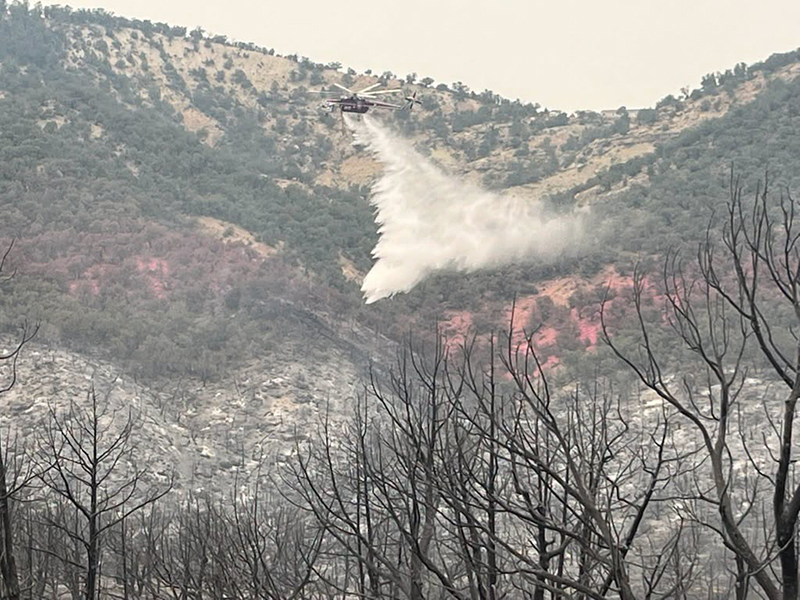 A helicopter dropping water on the Dry Creek Fire.